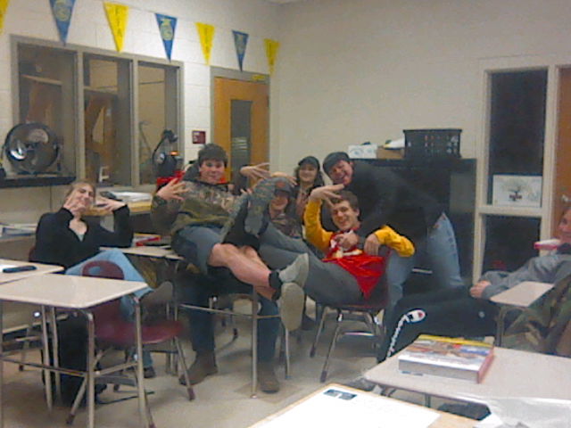 Students in a classroom crowding for a photo